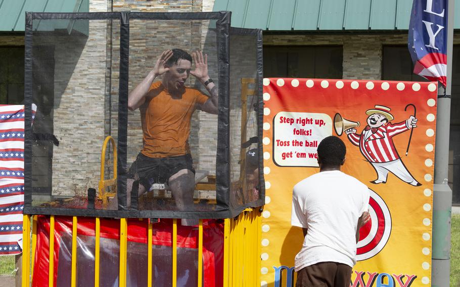 A man inside a dunking booth taunts a contestant.