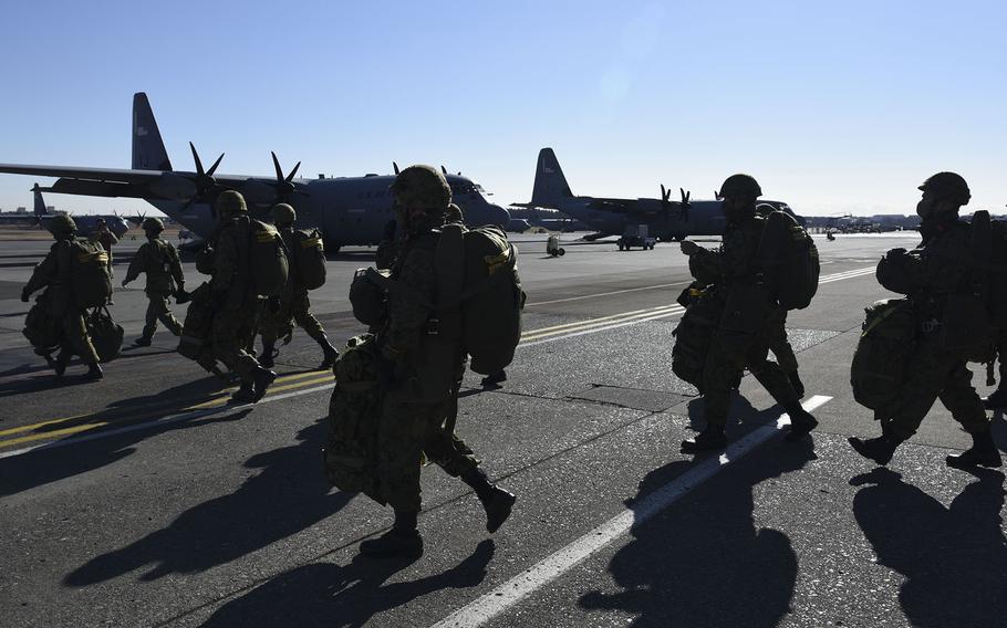 Japan Ground Self-Defense Force troops march with their parachuting gear toward an Air Force C-130J Super Hercules at Yokota Air Base, Japan, Thursday, Jan. 13, 2022.