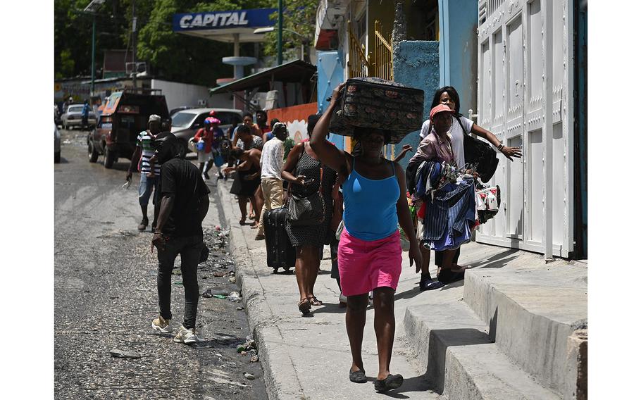 Resident evacuate the Carrefour Feuilles commune in Port-au-Prince, Haiti, on Aug. 15, 2023, as gang violence continues to plague the Haitian capital. 