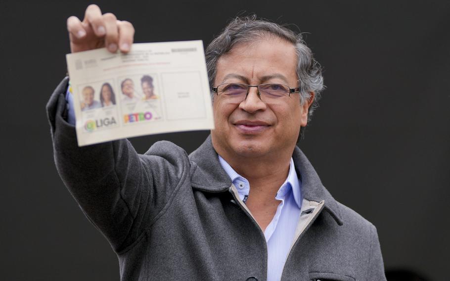 Gustavo Petro, presidential candidate with the Historical Pact coalition, shows his ballot before voting in a presidential runoff in Bogota, Colombia, Sunday, June 19, 2022.