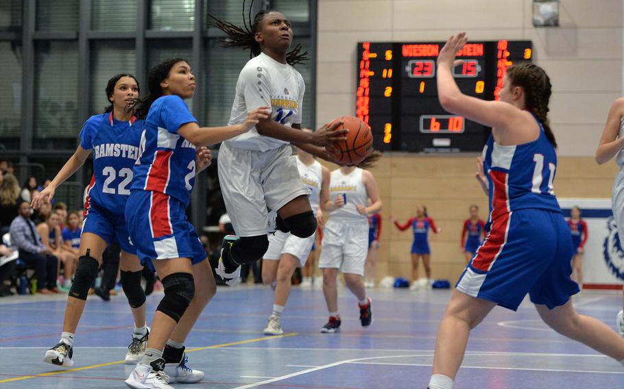 Wiesbaden’s Brandi Stanford looks to the basket after getting past Ramstein’s Aliya Jones, left, and Jasmine Jones while Royal Katya von Eicken waits to defend in the Division I championship game at the DODEA-Europe basketball championships in Ramstein, Germany, Feb. 18, 2023. The Warriors beat the Royals 43-34 to take the title.