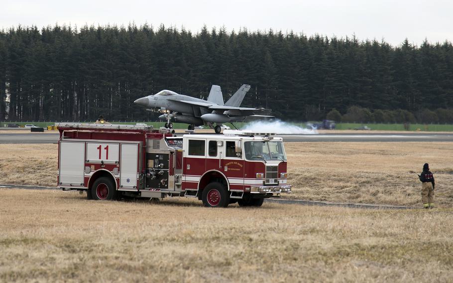 The 374th Civil Engineer Squadron's fire and emergency services stands by as a Navy F/A-18E Super Hornet from Strike Fighter Squadron 27 tests the aircraft arresting system at Yokota Air Base, Japan, Feb. 4, 2022.