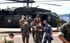 Royal Australian Air Force Group Capt. Lyle Holt, in blue, arrives with South Korean officers at Yokosuka Naval Base, Japan, Thursday, June 2, 2022. Holt leads U.N. Command-Rear out of Yokota Air Base in western Tokyo.