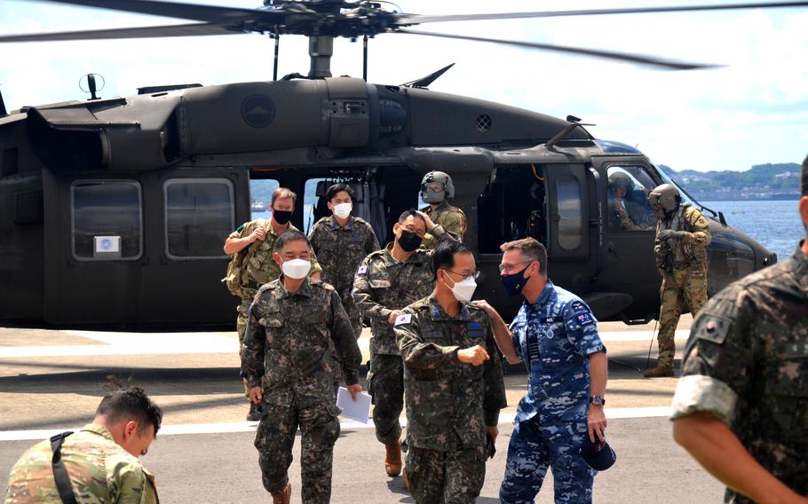 Royal Australian Air Force Group Capt. Lyle Holt, in blue, arrives with South Korean officers at Yokosuka Naval Base, Japan, Thursday, June 2, 2022. Holt leads U.N. Command-Rear out of Yokota Air Base in western Tokyo.