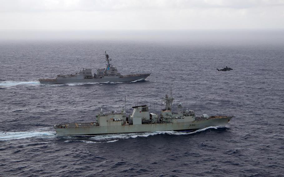 The guided-missile destroyer USS Chung-Hoon, top, sails in the South China Sea alongside the Canadian frigate HMCS Montreal, May 30, 2023.
