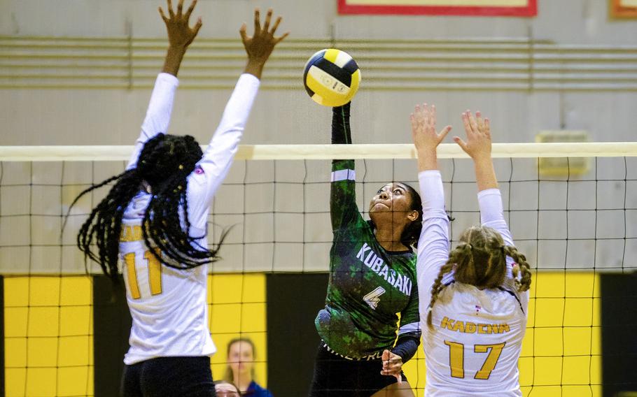 Kubasaki's Risha McGriff spikes between Kadena's Liza Young and Gabby Money during Tuesday's Okinawa volleyball match. The Dragons won in three sets to clinch their 18th straight island championship.