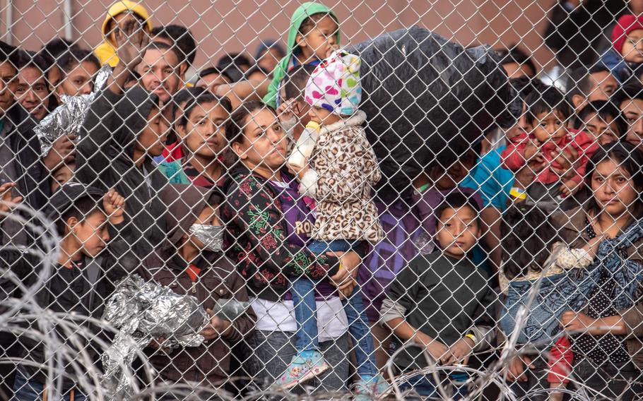 Migrants are gathered inside the fence of a makeshift detention center in El Paso on March 27, 2019.
