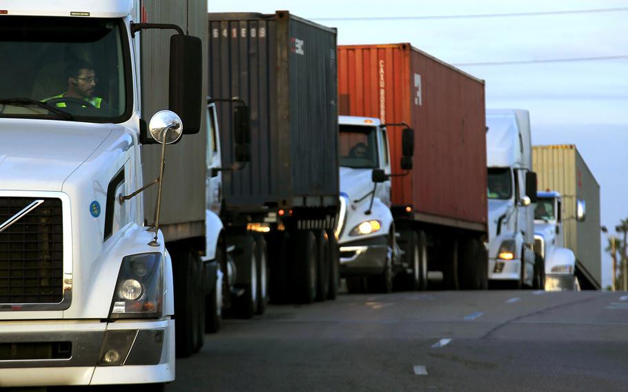 Trucks wait in line to take cargo to a pier in the Port of Long Beach in California on April 8, 2014, 
