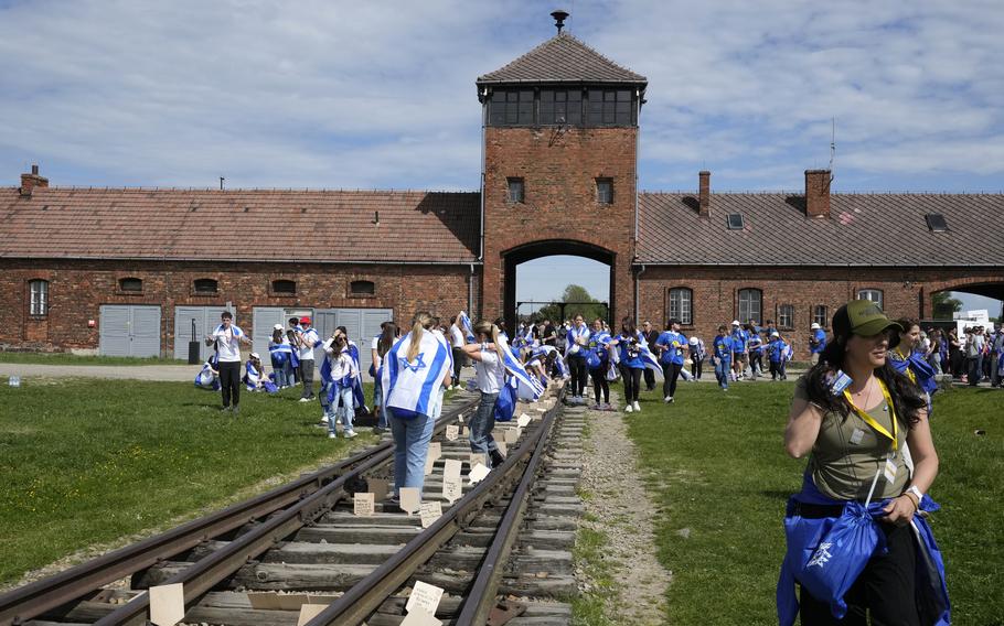 People walk through the former Nazi German death camp of Auschwitz-Birkenau as they attend the annual Holocaust remembrance event, the “March of the Living” in memory of the 6 million Holocaust victims in Oswiecim, Poland, Monday, May 6, 2024. 