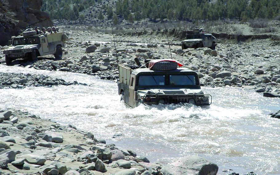 Humvees from the 1st Battalion, 508th Infantry Division use a riverbed as a road as they travel through eastern Afghanistan on a two-day mission to the villages of Zarwuk and Naka.