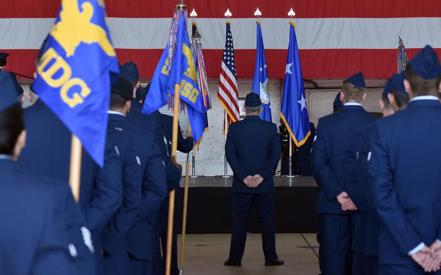 People standing in front of a large American flag.