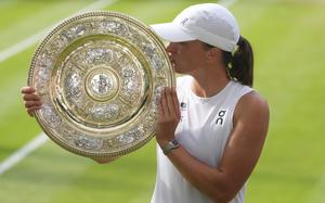 Swiatek kisses the trophy.