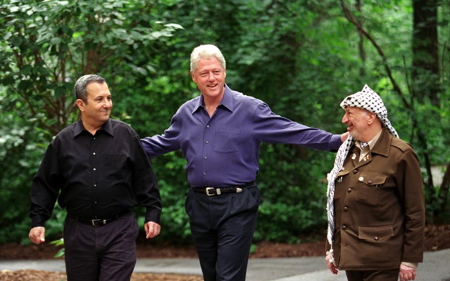 President Clinton walks with Prime Minister Ehud Barak of Israel and Yasser Arafat of the Palestinian Authority on the grounds of Camp David, July 11, 2000.