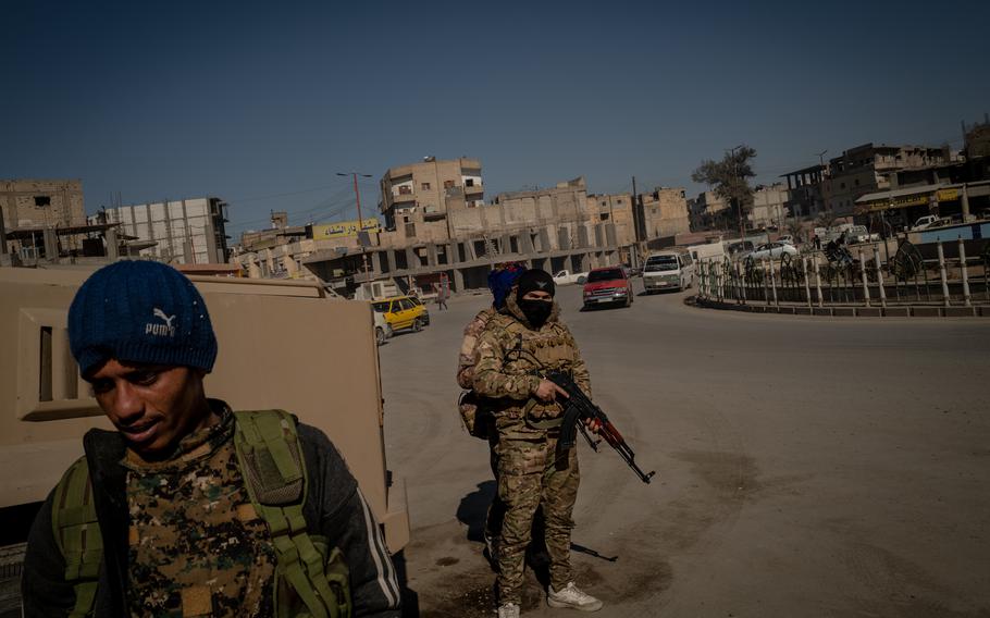 Fighters with the U.S.-backed Syrian Democratic Forces are on the lookout in Naim Square, in Raqqa, Syria, on Feb. 5, 2022. 