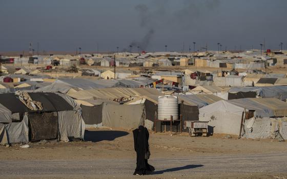 FILE - A woman walks in the al-Hol camp in northeastern Syria's Hasakeh province, where tens of thousands of mostly women and children linked to the Islamic State group have been living for years, Thursday, Jan. 30, 2025. (AP Photo/Bernat Armangue,File)