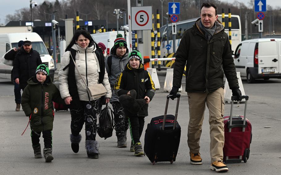Polish-born German parliamentarian Paul Ziemiak helps refugees from Ukraine cross the Ukranian-Polish border at Medyka, March 2, 2022.