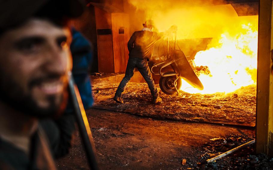 Workers toss recycled metals into a furnace to burn on a production line at a steel plant that Yu Minghui, a 51-year-old entrepreneur from China, partially owns and operates, in Kabul, Afghanistan, Wednesday, Sept. 7, 2022. The Taliban takeover of Afghanistan has upended the working lives of hundreds of thousands of people and made most international businesses in the country race for the exit, but Chinese entrepreneurs see an opportunity.