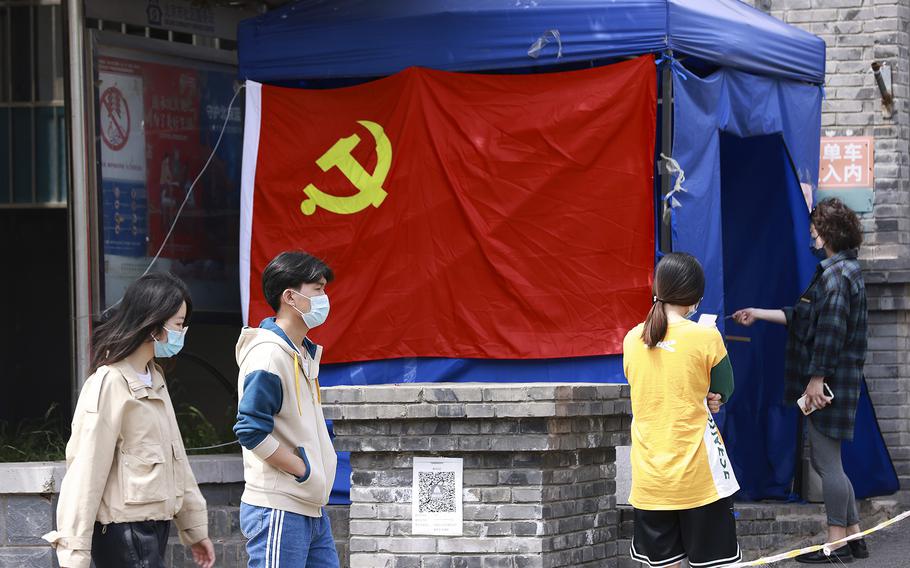 People wait in line for a swab test at a COVID-19 test site on May 19, 2022, in Beijing as China is trying to contain a spike in coronavirus cases in the capital.