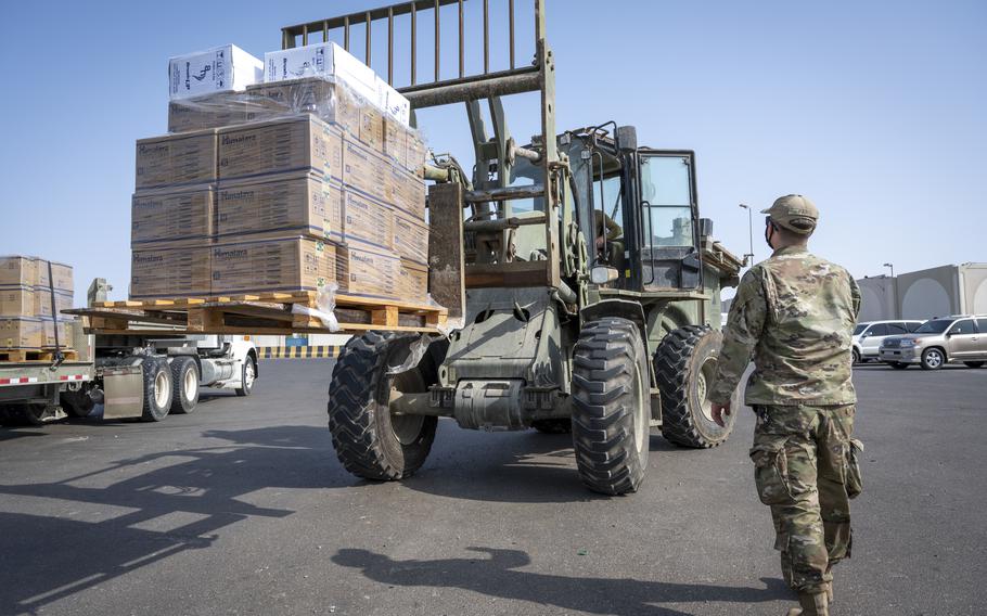An Air Force airman with the 380th Expeditionary Contracting Squadron, 380th Expeditionary Logistics Readiness Squadron and the 380th Expeditionary Civil Engineer Squadron gather humanitarian relief supplies at Al Dhafra Air Base, United Arab Emirates, on Aug 20, 2021. 