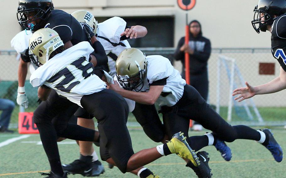 Osan running back Jaylon Grant drags Humphreys defenders Emmanuel Lawson and Luke Robinson as he runs the football.