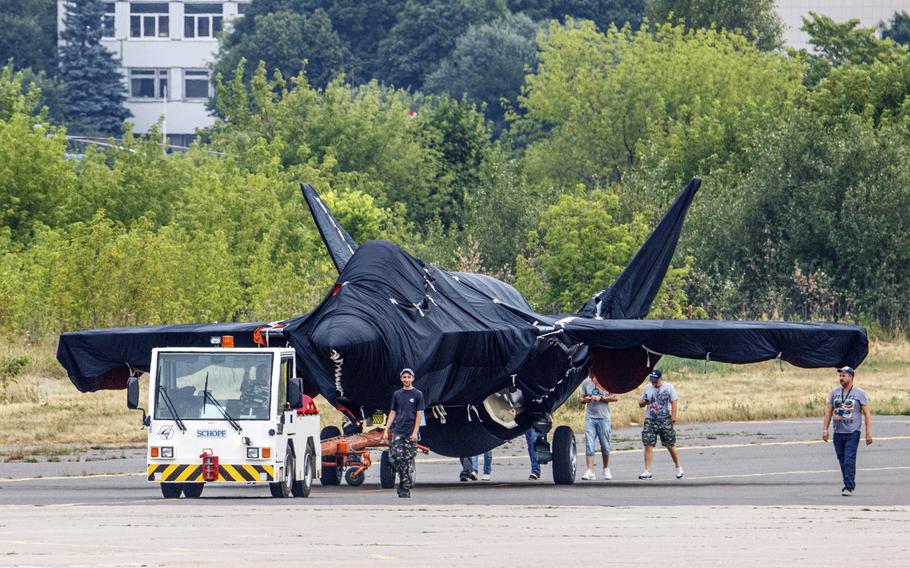 Hidden under tarpaulin, a prospective Russian fighter jet is seen being towed to a parking spot before its presentation at the Moscow international air show in Zhukovsky outside Moscow, Russia, Thursday, July 15, 2021.