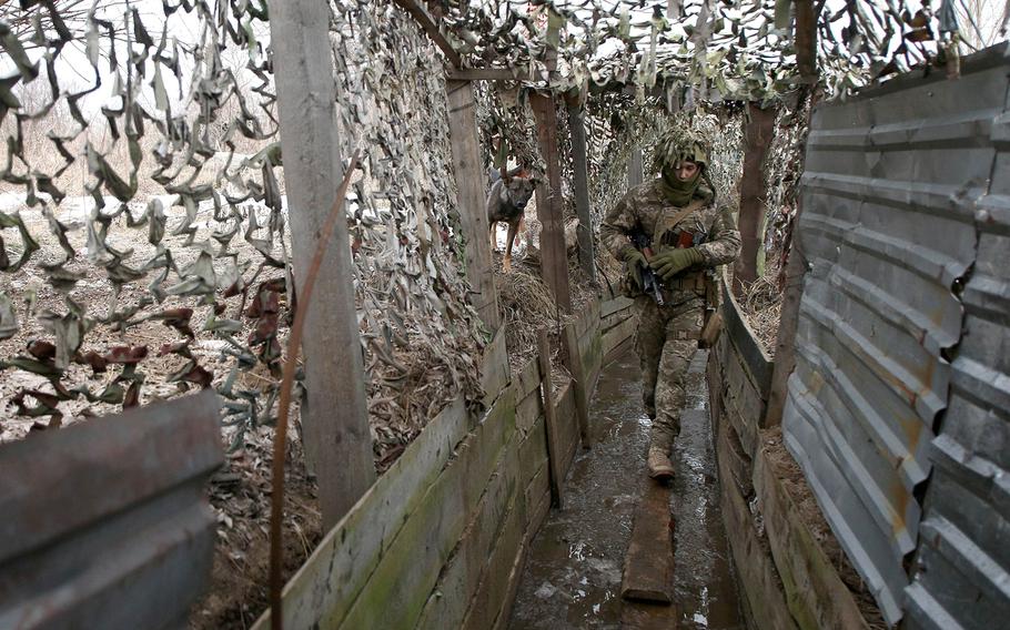 A Ukrainian Military Forces soldier walks in a trench on the front line with Russia-backed separatists near to Avdiivka, Donetsk, in southeastern Ukraine, on Jan. 9, 2022.