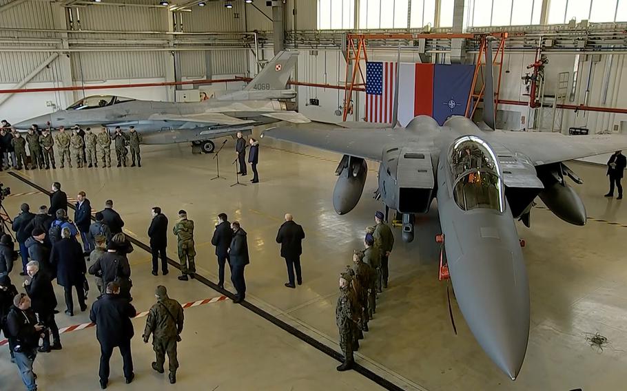 NATO Secretary-General Jens Stoltenberg and Polish President Andrzej Duda speak with reporters while standing between a Polish F-16 and a U.S. Air Force F-15 from Seymour Johnson Air Force Base, N.C,. at Lask Air Base, Poland, March 1, 2022. 