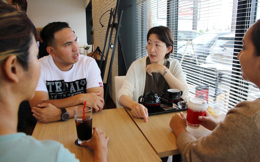 Army Master Sgt. John Ross Valino chats with Nagasaki resident Takako Kikuchi at the Segafredo coffee shop in Yomitan, Okinawa, Tuesday, June 20, 2023.