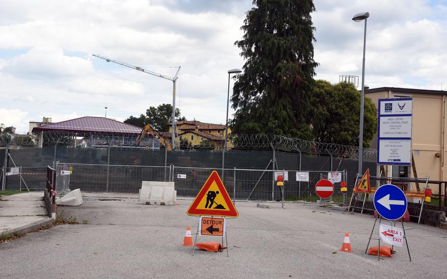 Construction signs and fences block the gate of a military installation.