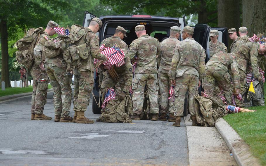 Soldiers from the 3rd Infantry Regiment, also known as The Old Guard, grab more flags on Thursday, May 23, 2024, to place at gravesites to honor service members for Memorial Day. The annual event, “Flags In,” is an annual event that takes four hours for nearly 1,500 soldiers, including about 100 joint service members, according to Arlington National Cemetery.  