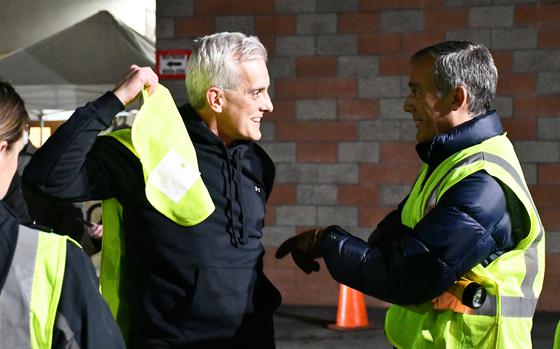 Department of Veterans Affairs Secretary Denis McDonough, left, greets Los Angeles Mayor Eric Garcetti, right, in downtown Los Angeles on Thursday, Feb. 24, 2022. McDonough, Garcetti, and dozens of other volunteers counted the number of homeless individuals living in Skid Row, a neighborhood that contains one of the largest homeless populations in the country.  