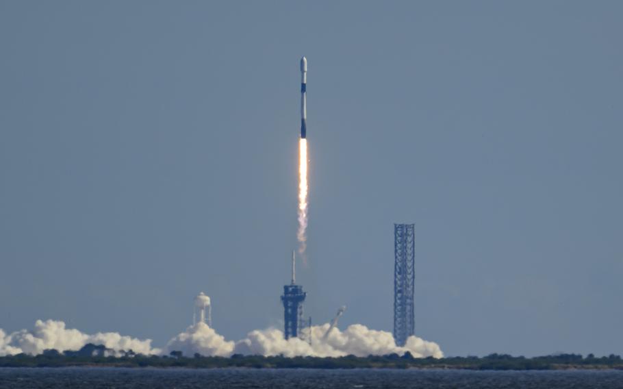 A rocket launching from a launch pad against a blue sky.