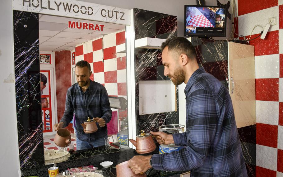 Talib Shaheen, a barber, prepares tea for potential customers at his shop outside the gate of Incirlik Air Base in southern Turkey, on Feb. 24, 2023. 