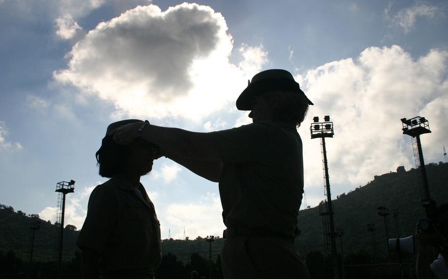 Chief Petty Officer Lisa Lazo, 32, stands tall as a sponsor places her new chief’s cover atop her head during Friday’s pinning ceremony, held at Carney Park in Naples, Italy.