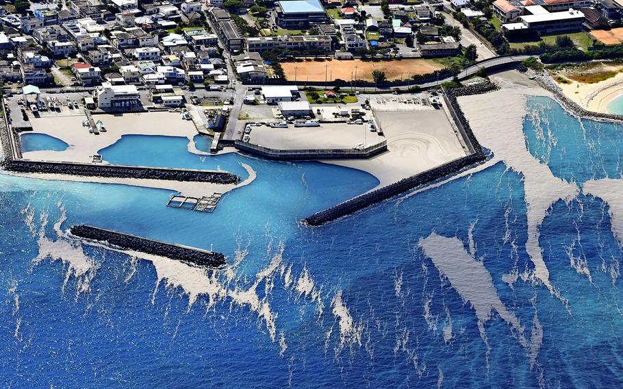 Gray drifts of floating pumice are seen at the fishing port of Hentona in Kunigami, Okinawa Prefecture, on Wednesday morning.