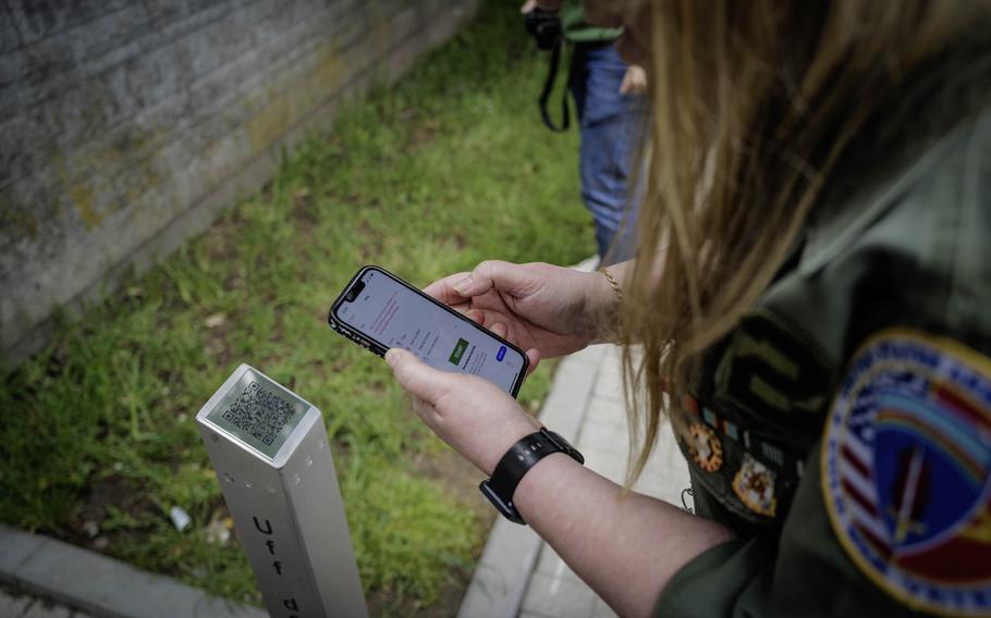 Edith Allison, who served as an intelligence analyst with the 2nd Military Intelligence Battalion from 1978 to 1981, uses her phone to access the new audio guide during the unveiling ceremony at Husterhöh Kaserne in Pirmasens, Germany, on Wednesday, May 8, 2024.