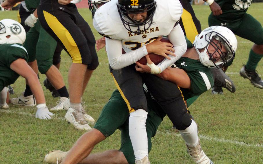 Kadena running  back Anthony Chavez gets hauled down by the Kubasaki defense.