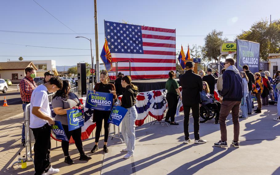 Supporters of Gallego hold signs during the campaign event. 