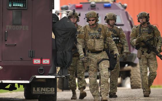 Members of law enforcement agencies search for shooting suspect, Vance Boelter, at a house Sunday, June 15, 2025, in Belle Plaine, Minn. (AP Photo/George Walker IV)