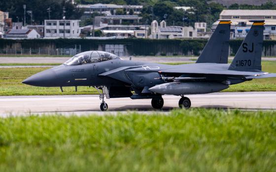 A U.S. Air Force F-15 Eagle fighter jet taxiing on a runway at an airbase. 