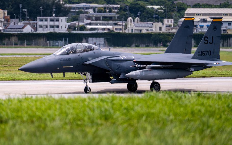 A U.S. Air Force F-15 Eagle fighter jet taxiing on a runway at an airbase. 