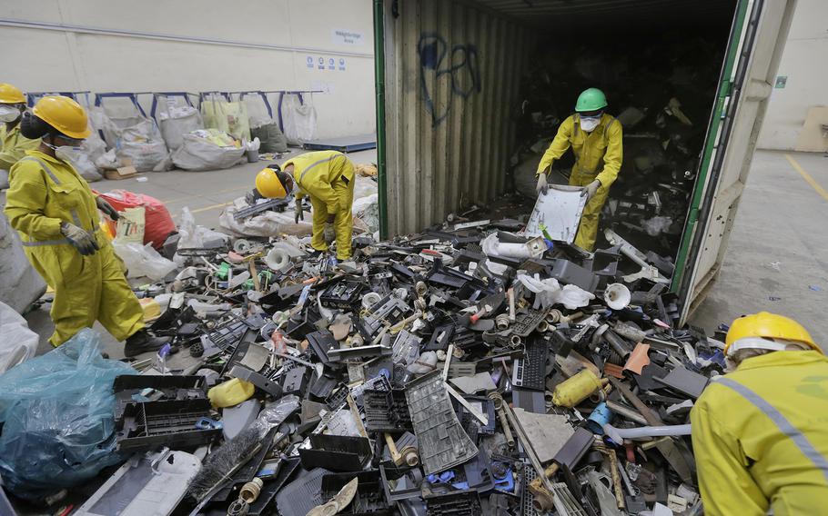 Workers unload and sort through a container full of electronic waste that was collected from a Nairobi slum and brought in for recycling, at the East African Compliant Recycling facility in Machakos, near Nairobi, in Kenya on Aug. 18, 2014.
