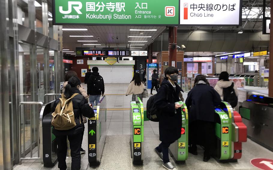 Commuters pass through Kokubunji Station in western Tokyo, Friday, Jan. 3, 2023.