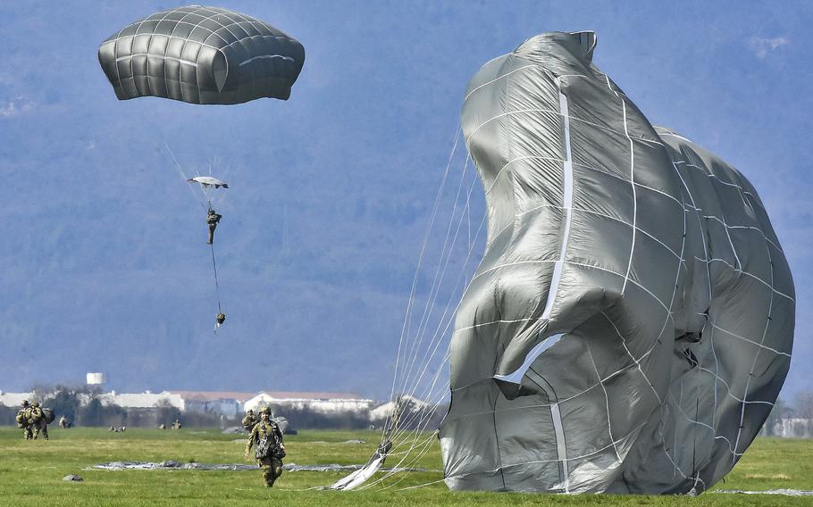 Some soldiers leave the Juliet Drop Zone near Vajont, Italy, as others gather parachutes and still others float to the ground during an all-female jump Thursday, March 14, 2024.