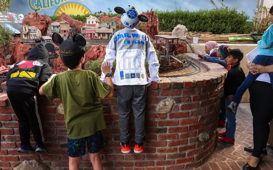 Fans walk Jan. 10 in the Disneyland-inspired Anaheim Hills backyard of the Sheegogs, lifting themselves up over the brick walls to look a little closer at the miniatures laid out in front of them. The couple hosted a free open house for the public. They welcome guests in the spring and fall. 