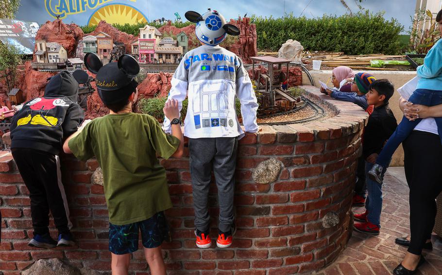 Fans walk Jan. 10 in the Disneyland-inspired Anaheim Hills backyard of the Sheegogs, lifting themselves up over the brick walls to look a little closer at the miniatures laid out in front of them. The couple hosted a free open house for the public. They welcome guests in the spring and fall. 