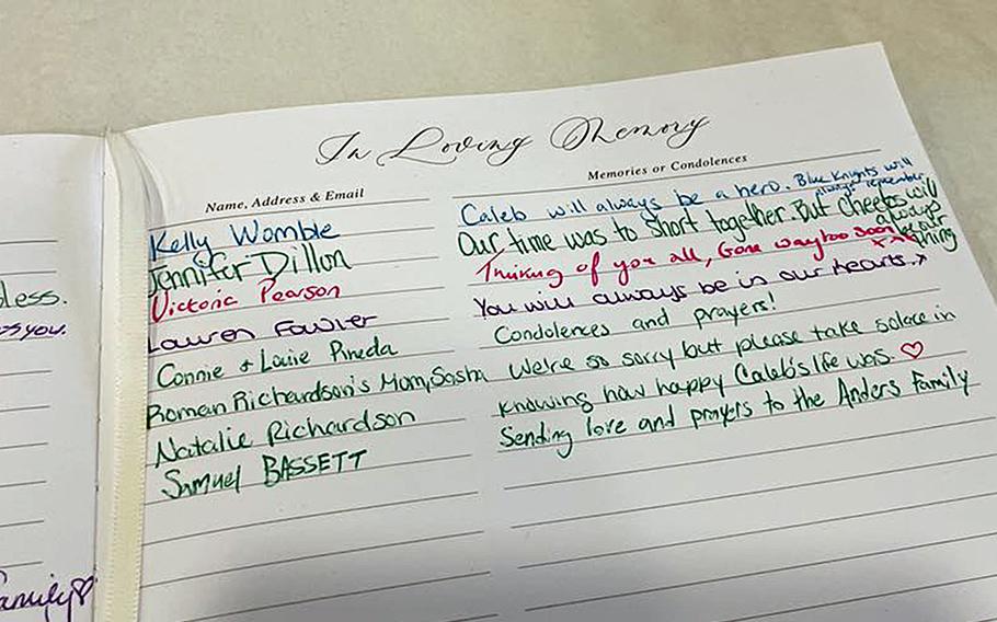A book reads “In Loving Memory” at the top and contains handwritten messages such as “You will always be in our hearts.”