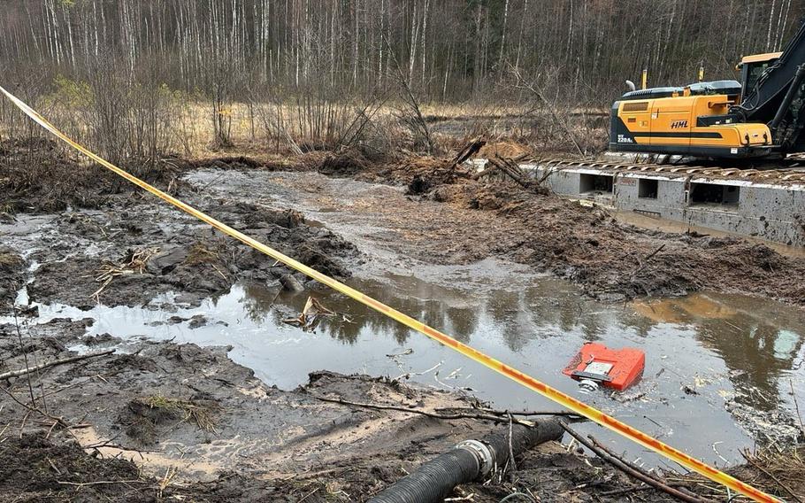 Heavy equipment seen on the right while a bog takes up most of the image.