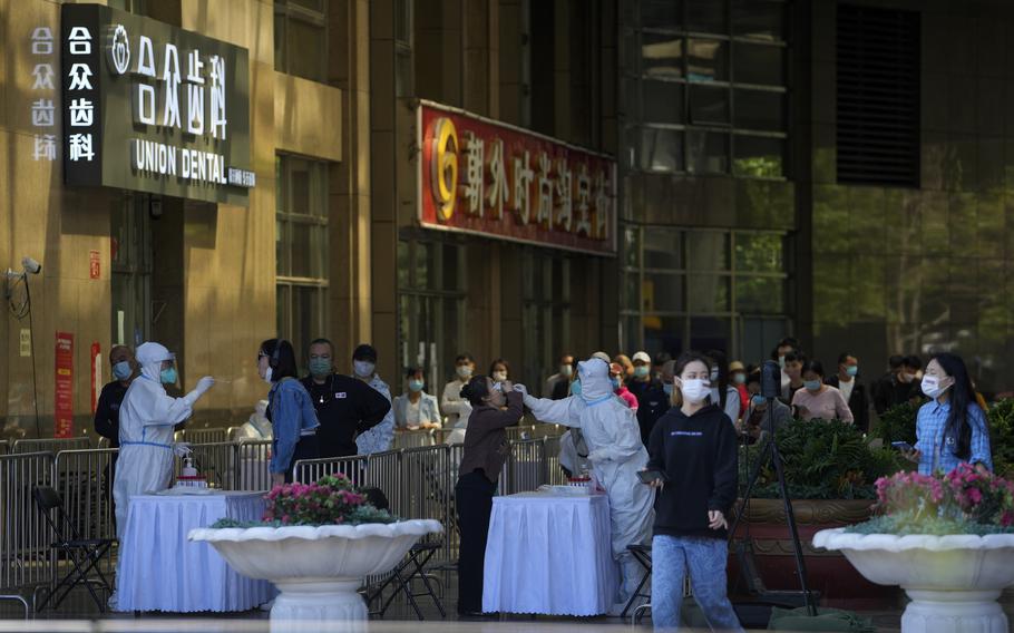 Residents line up for COVID mass testing set up at a shuttered commercial office complex on Sunday, May 15, 2022, in Beijing. (AP Photo/Andy Wong)