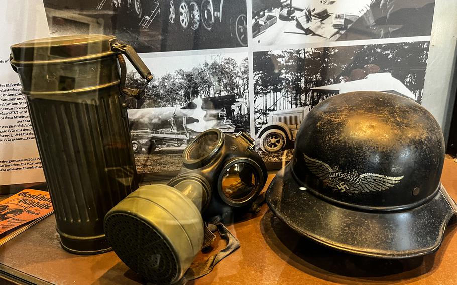 A World War II gas mask kit and helmet once used by a German air raid shelter troop is on display at the former government bunker in Bad Neuenahr-Ahrweiler, Germany, Feb. 13, 2022. During the war, the former railroad tunnel served as an underground construction facility and shelter from allied aerial bombing runs.